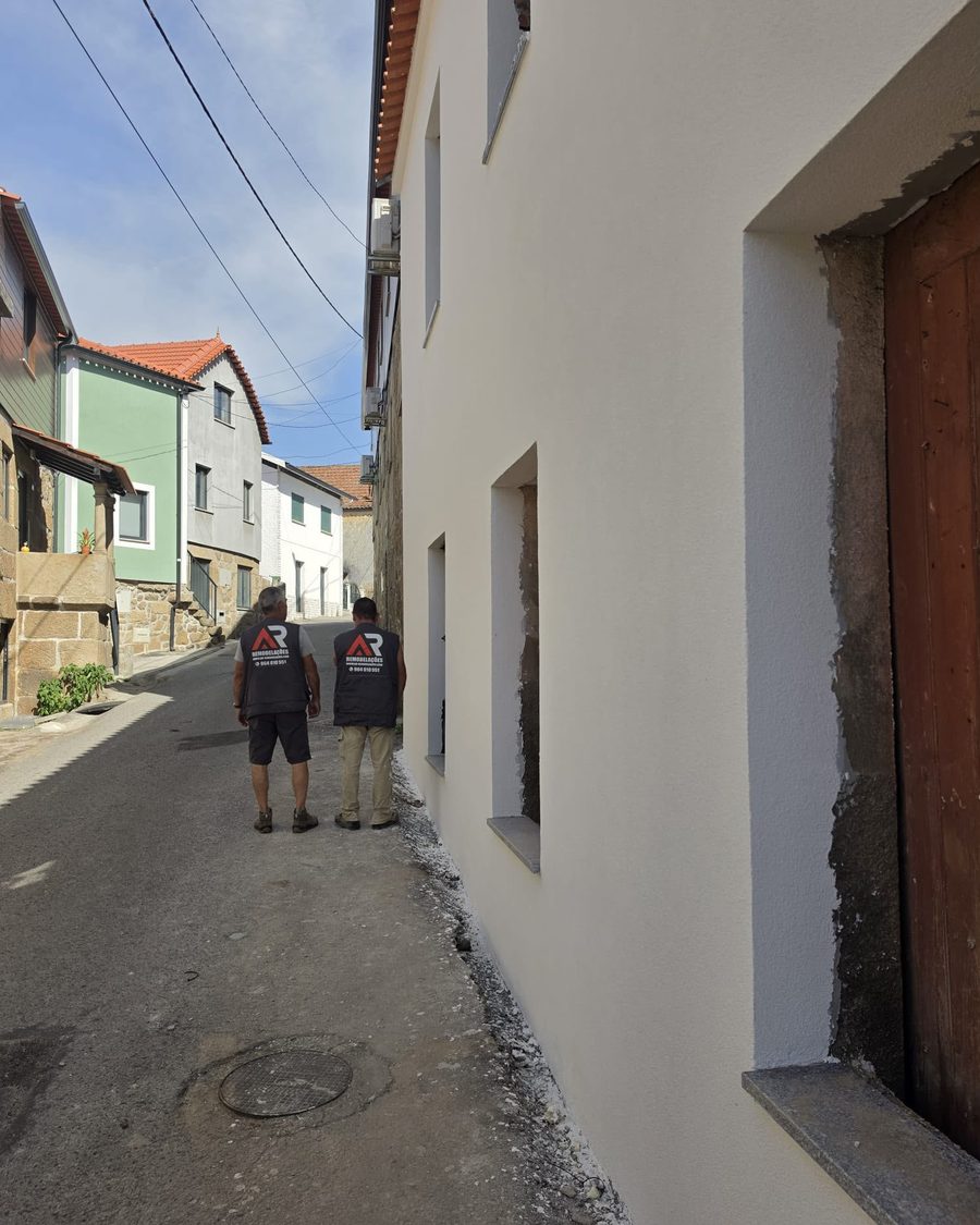 Dois elementos da equipa AR Remodelações na rua, junto à fachada acabada
