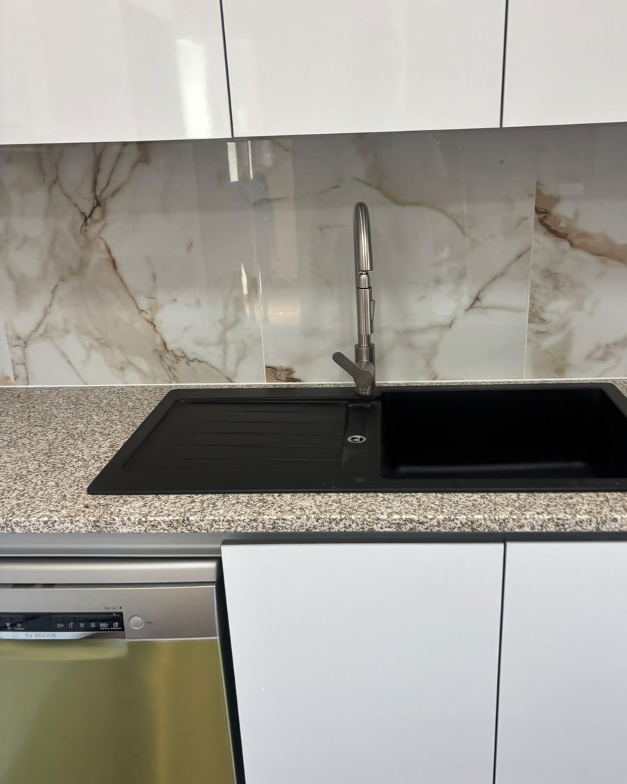 Bancada de pedra com lava-loiça preto e torneira extensível