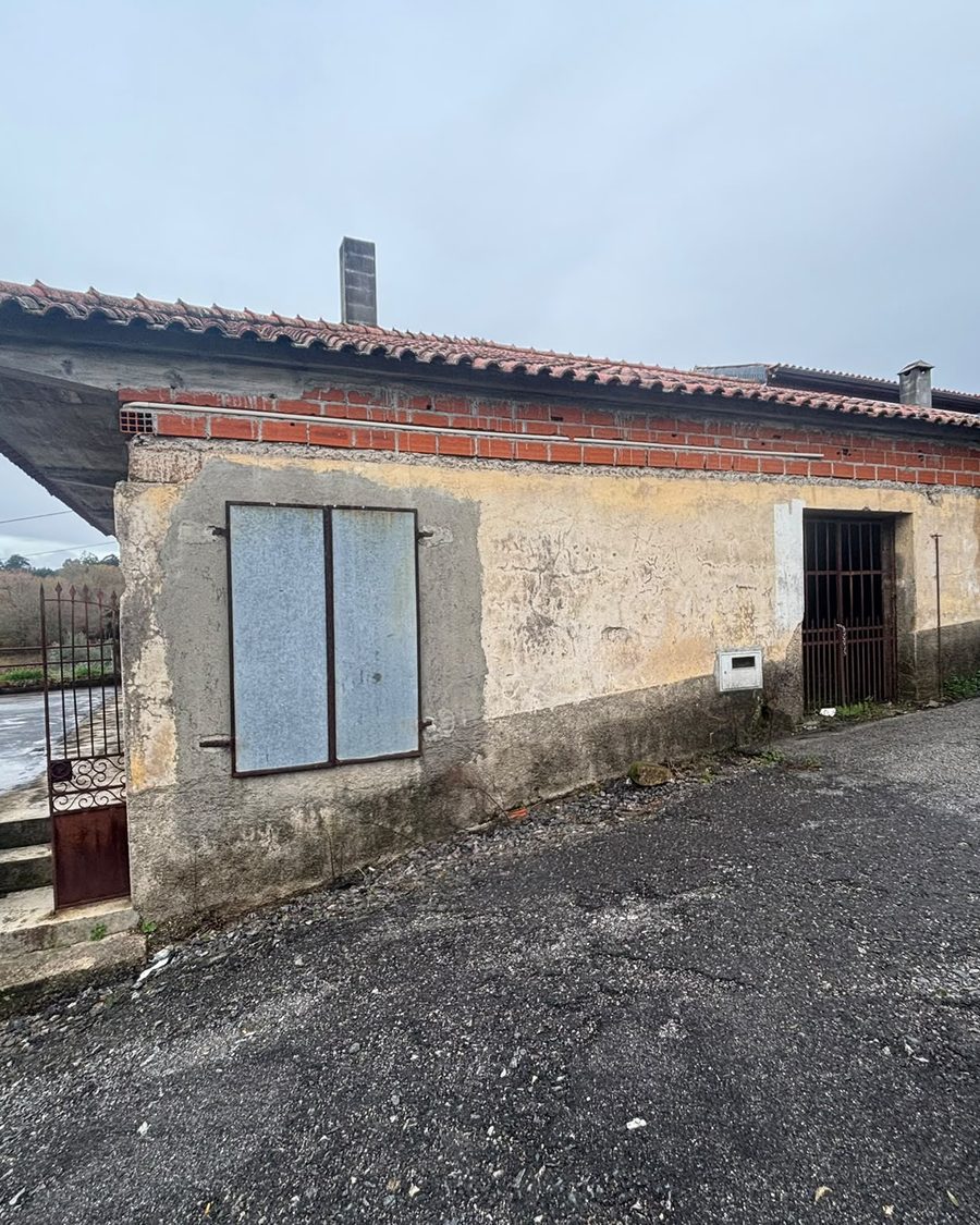 Moradia térrea antes da obra, com o reboco a cair e tijolo à vista por baixo do beiral